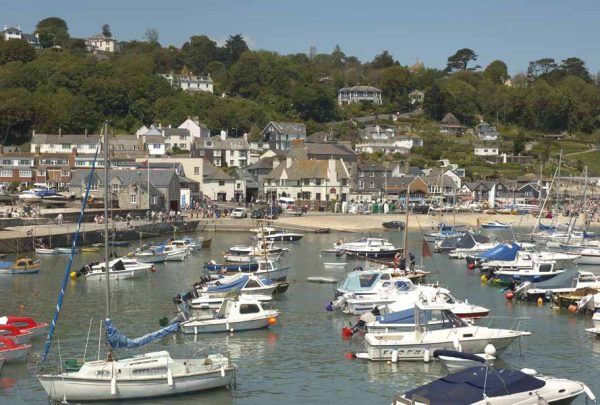 Lyme Regis marina filled with boats, looking at the beach with houses