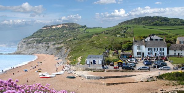Seatown beach looking at a pub and car park with grassy hill above the beach