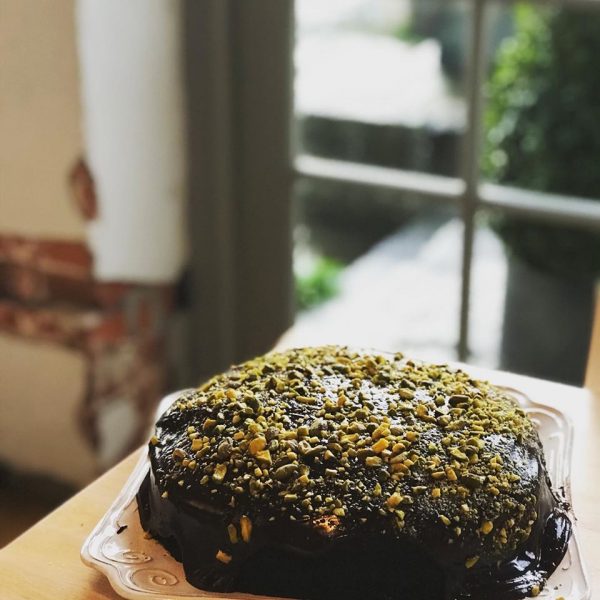 Chocolate cake on a counter by a window looking out at a garden