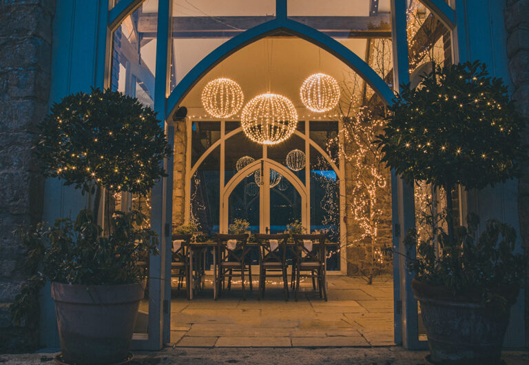 High-ceiling chapel with christmas lights above and around a dinner table